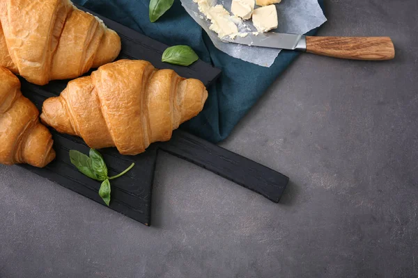Tablero Madera Con Sabrosos Croissants Mantequilla Sobre Fondo Texturizado Gris — Foto de Stock