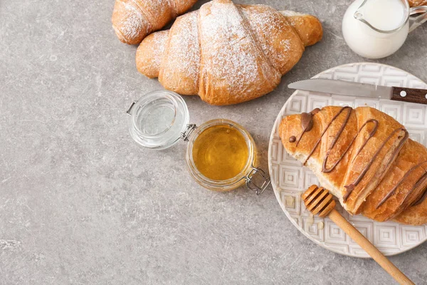 Placa Con Sabroso Croissant Miel Sobre Fondo Gris — Foto de Stock