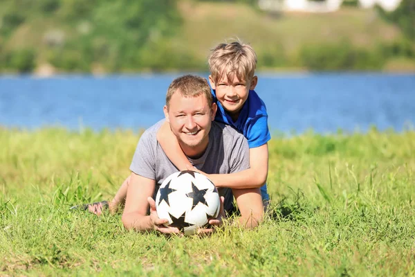 幸福的父亲和儿子在河附近足球 — 图库照片