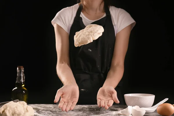 Woman kneading dough for bakery on kitchen table