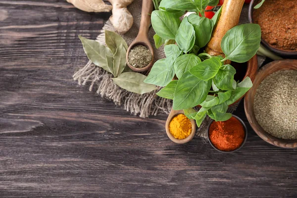 Ahşap arka plan üzerinde otlar ile çeşitli baharatlar