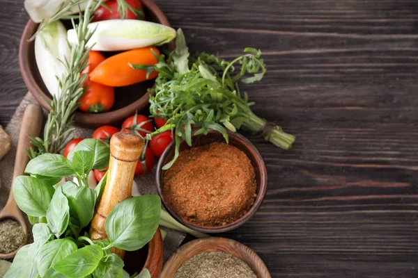 Ahşap arka plan üzerinde sebze ve otlar ile çeşitli baharatlar