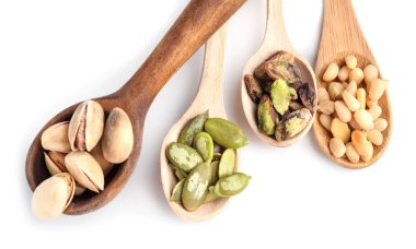 Beyaz arka plan üzerinde farklı fındık ile tahta kaşıklar