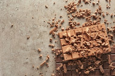 Lezzetli çikolata bar ve gri arka plan üzerinde parçalar