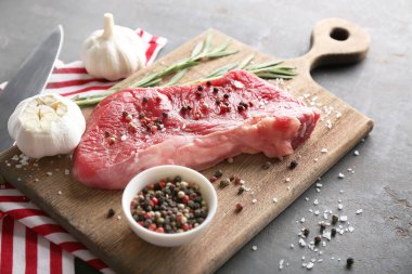 Fresh raw meat with spices on wooden board
