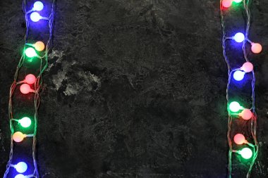 Koyu arka plan üzerinde parlayan Noel çelenk