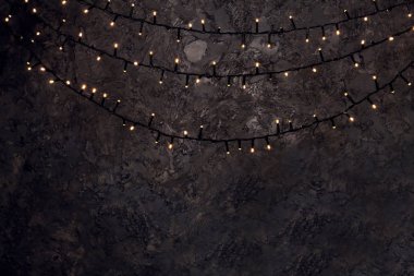 Koyu arka plan üzerinde parlayan Noel çelenk