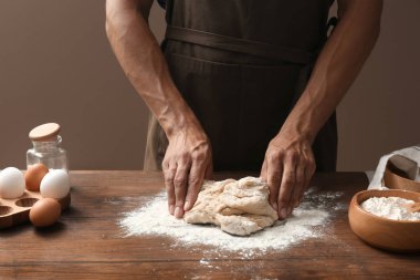 Adam ahşap masa üzerinde hamur yoğurma