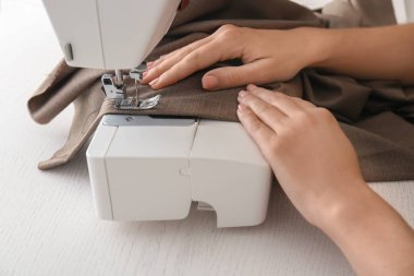 Atelier dikiş makinesi üzerinde çalışan kadın terzi