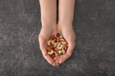 Farklı fındık gri arka plan üzerinde tutan kadın