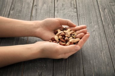 Farklı fındık ahşap arka plan üzerinde tutan kadın