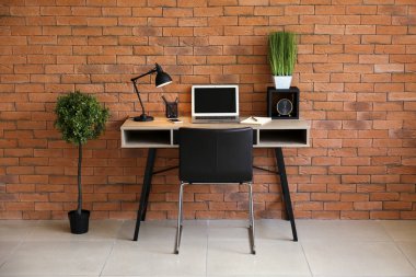 Şık çalışma alanı yakınındaki duvara ofiste masa üstünde laptop ile