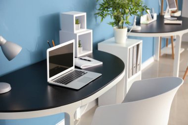 Dizüstü bilgisayarda Office renk duvarının yakınında tablo ile şık İşyeri