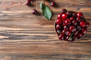 Olgun kiraz ahşap arka plan ile kase