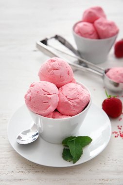 Lezzetli çilekli dondurma Beyaz ahşap zemin üzerinde ile kase