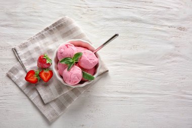 Lezzetli çilekli dondurma Beyaz ahşap zemin üzerinde ile kase