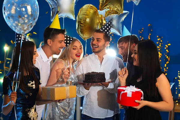 年轻人与美味的蛋糕和他的朋友在俱乐部的生日聚会上 — 图库照片