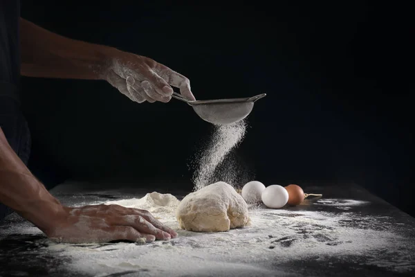 黒地の生地に小麦粉をふるい男 — ストック写真