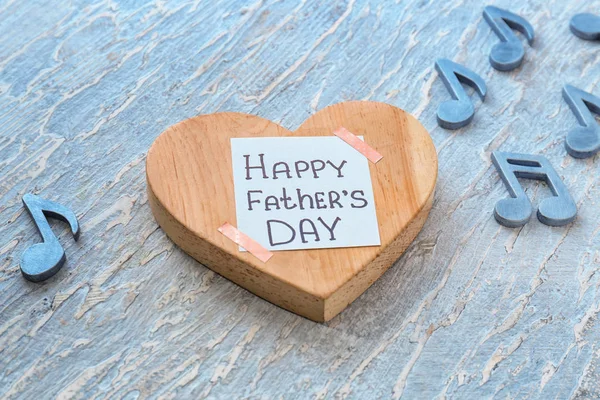 Heart with words HAPPY FATHERS DAY on wooden background