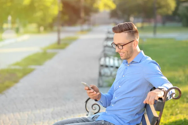 Красивый Мужчина Мобильным Телефоном Лежит Скамейке Зеленом Парке — стоковое фото