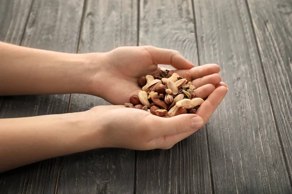 Farklı fındık ahşap arka plan üzerinde tutan kadın