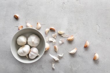 Gri dokulu arka plan üstünde taze sarımsak ile kase