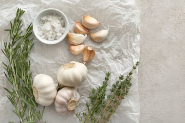 Sarımsak ve tuz gri dokulu arka plan üzerinde taze otlar