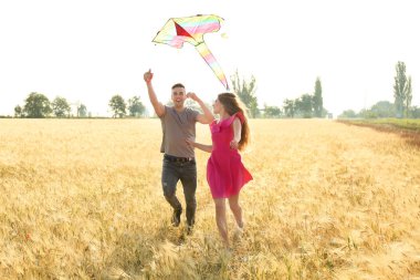 Mutlu genç çift uçan uçurtma bir alanda