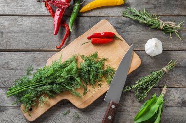 Biber ve sarımsak ahşap arka plan üzerinde taze otlar