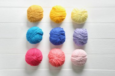 Beyaz ahşap zemin üzerinde iplik örgü topları ile kompozisyon