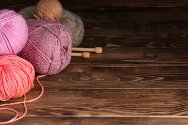 İplik ve iğneler ahşap arka plan üzerinde örgü topları