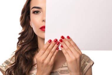 Güzel manikürlü ve beyaz arka planda boş posteri olan genç bir kadın.