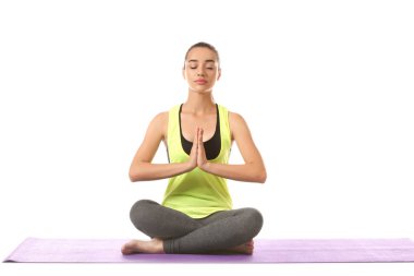 Beyaz arka planda yoga yapan genç bir kadın.