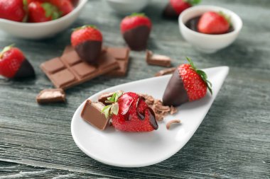 Taze çilek ve çikolata ahşap arka plan üzerinde plaka