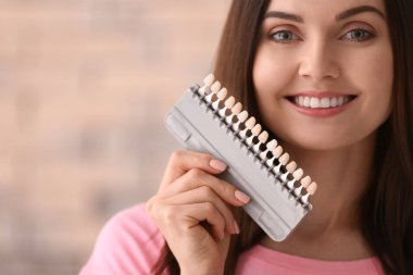 Güzel genç kadın dişleri olan renk arka plan bulanık üzerinde örnekleri