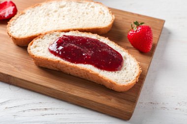 Tost ve ahşap masa, closeup üzerinde çilek reçeli ile kurulu