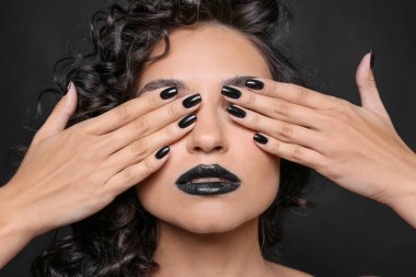 Koyu arka plan üzerinde siyah manikür moda bayan