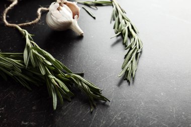 Taze biberiye ve sarımsak koyu arka plan üzerinde