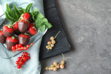 Gri masada lezzetli çikolata batırılmış çilek ile kase