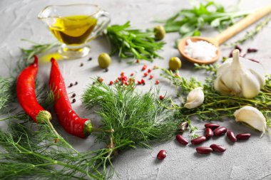 Gri dokulu arka plan üzerinde baharatlar ile taze otlar