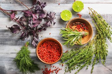 Ahşap arka plan üzerinde baharatlar ile taze otlar