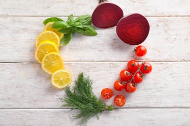 Taze otlar, sebzeler ve ahşap zemin üzerine dilimlenmiş limon ile kompozisyon