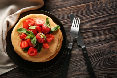 Plaka lezzetli gözleme ve ahşap masa üzerinde çilek ile