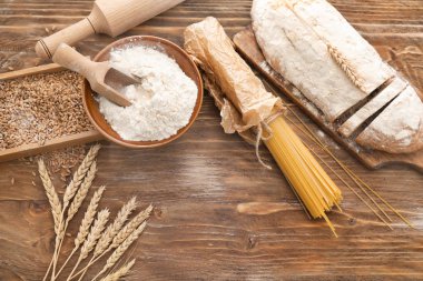 Buğday unu, ekmek ve makarna üzerine ahşap arka plan kompozisyonu