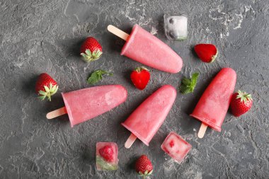 Delicious strawberry popsicle with berries on grey background clipart