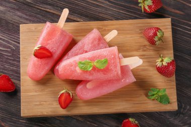 Lezzetli Çilekli dondurmayı ahşap tahta üzerinde çilek ile