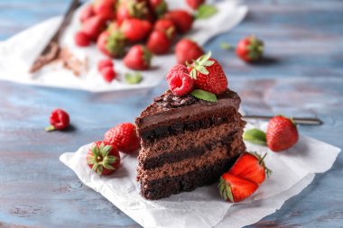 Ahşap masa üzerinde meyveleri lezzetli çikolatalı kek parçası