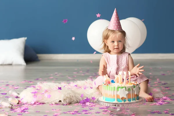 屋内のふわふわの絨毯の上に座っての誕生日ケーキとかわいい女の子 — ストック写真