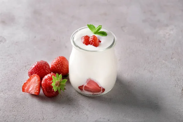 灰色纹理背景下的酸奶和草莓玻璃罐 — 图库照片