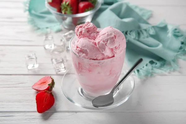 木桌上有美味草莓冰淇淋的玻璃杯 — 图库照片